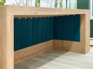 ciemno-zielone panele tapicerowane w zabudowie łóżka dziecięcego