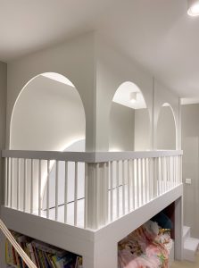 biała antresola w pokoju dziecięcym z łukami i zabudową łóżka