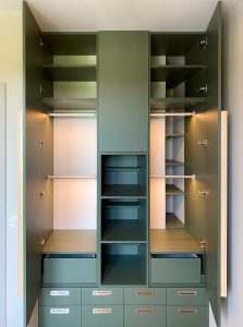 ciemno - zielona szafa w pokoju dziecięcym z wieloma półkami i szufladami